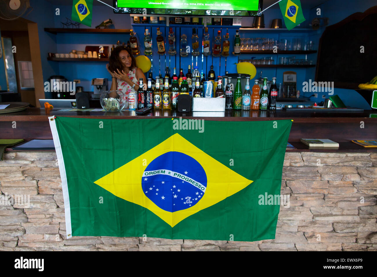 A Brazilian flag displayed on a bowl of tropical fruit in a bar with a