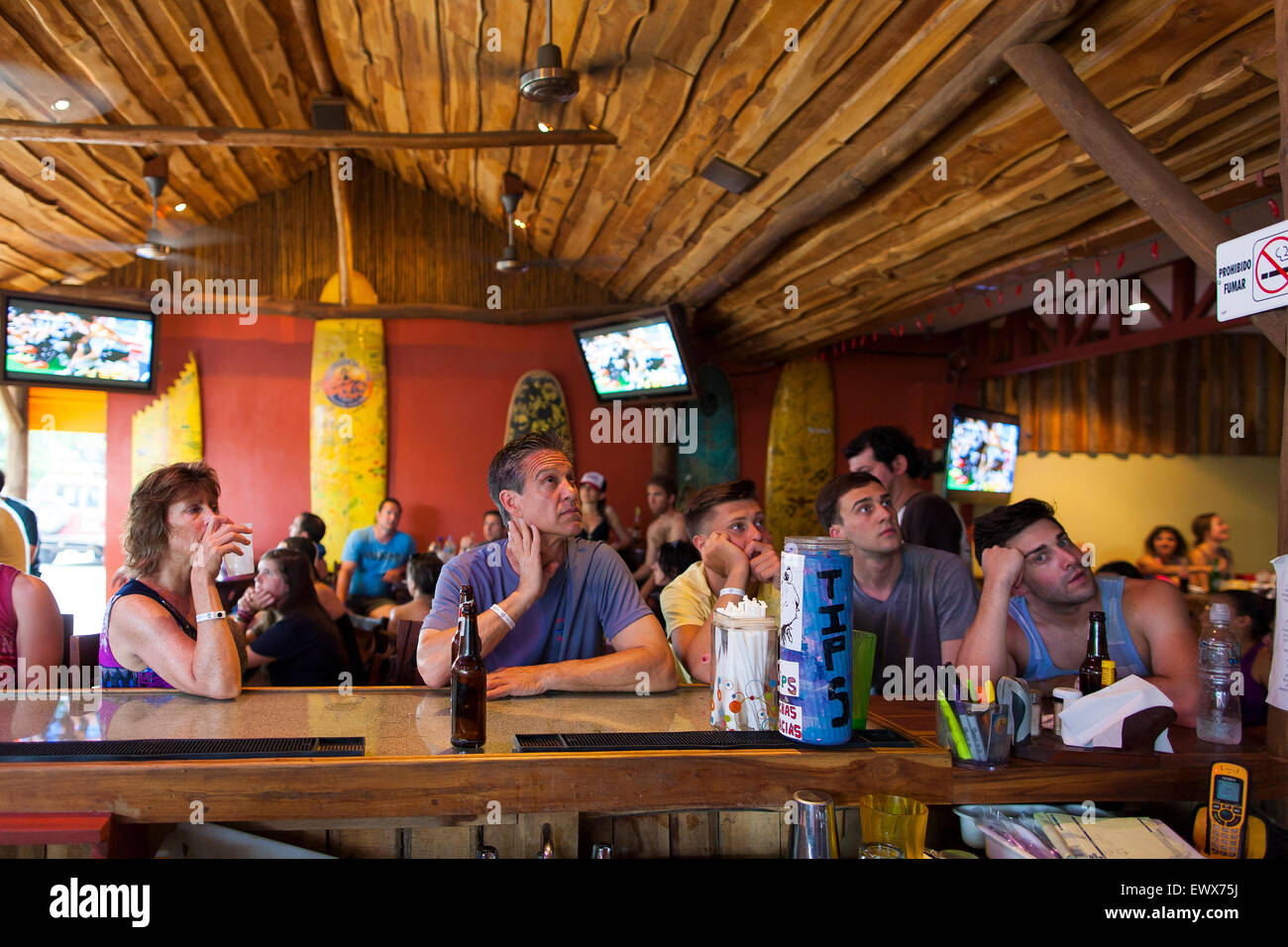 American and Canadian tourists glued to a sports game in a bar in