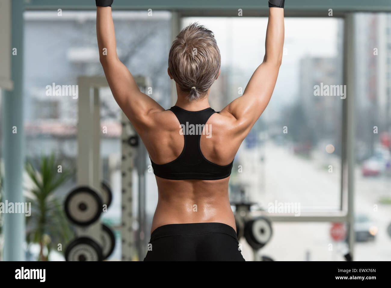 Female Athlete Doing Pull Ups - Chin-Ups In The Gym Stock Photo