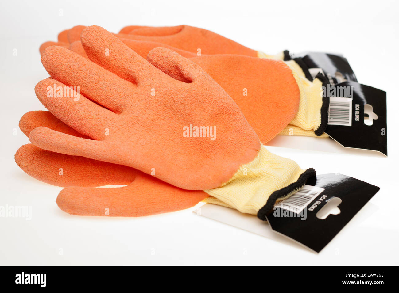 Three pairs of orange and yellow  non slip latex coated and knitted seamless safety wear work gloves Stock Photo