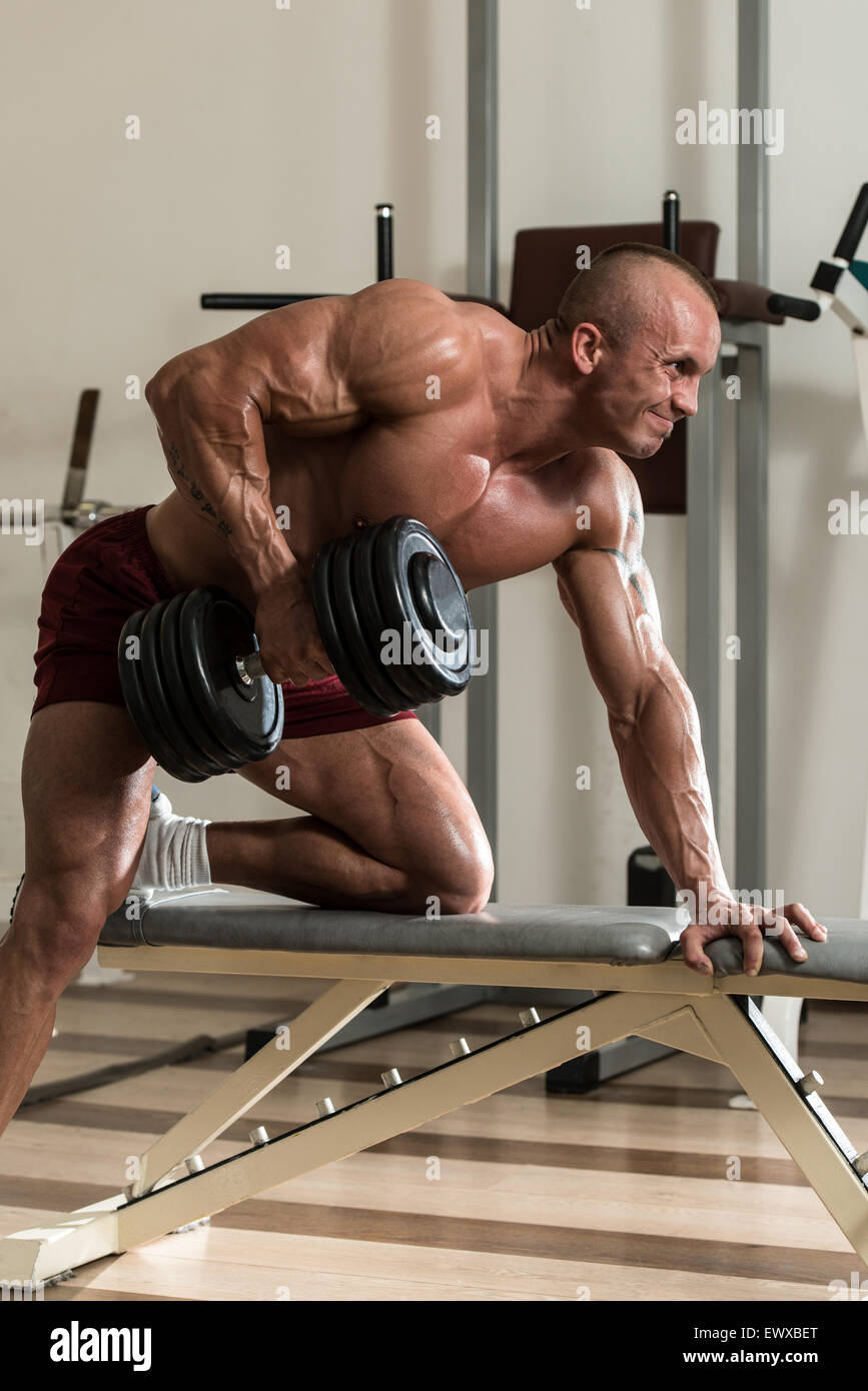 Healthy Man Doing Back Exercises In The Gym With Dumbbell Stock Photo -  Alamy