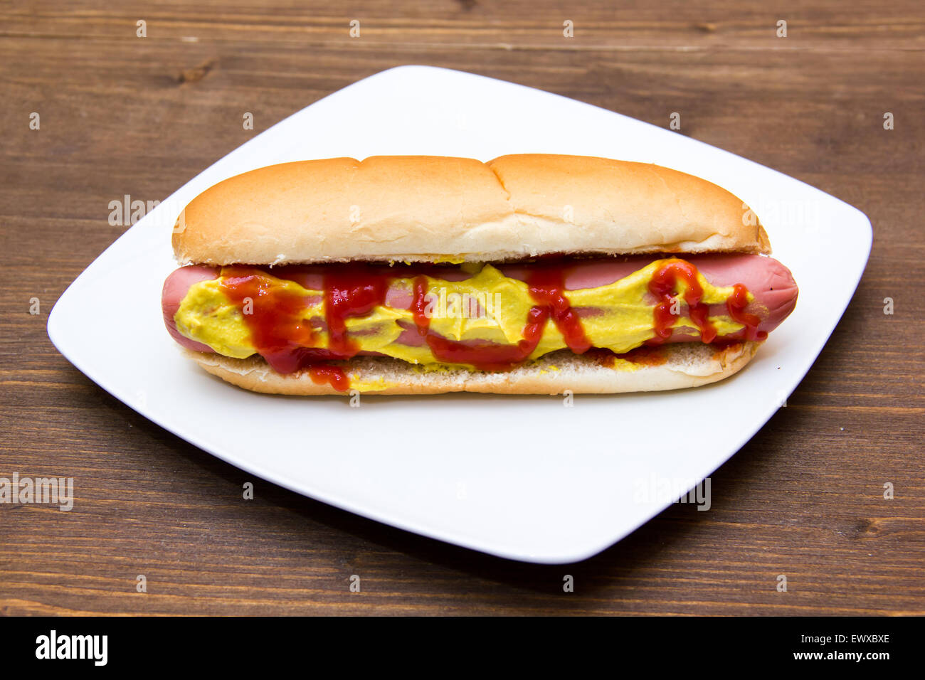 Hot dog on plate on wooden table Stock Photo Alamy