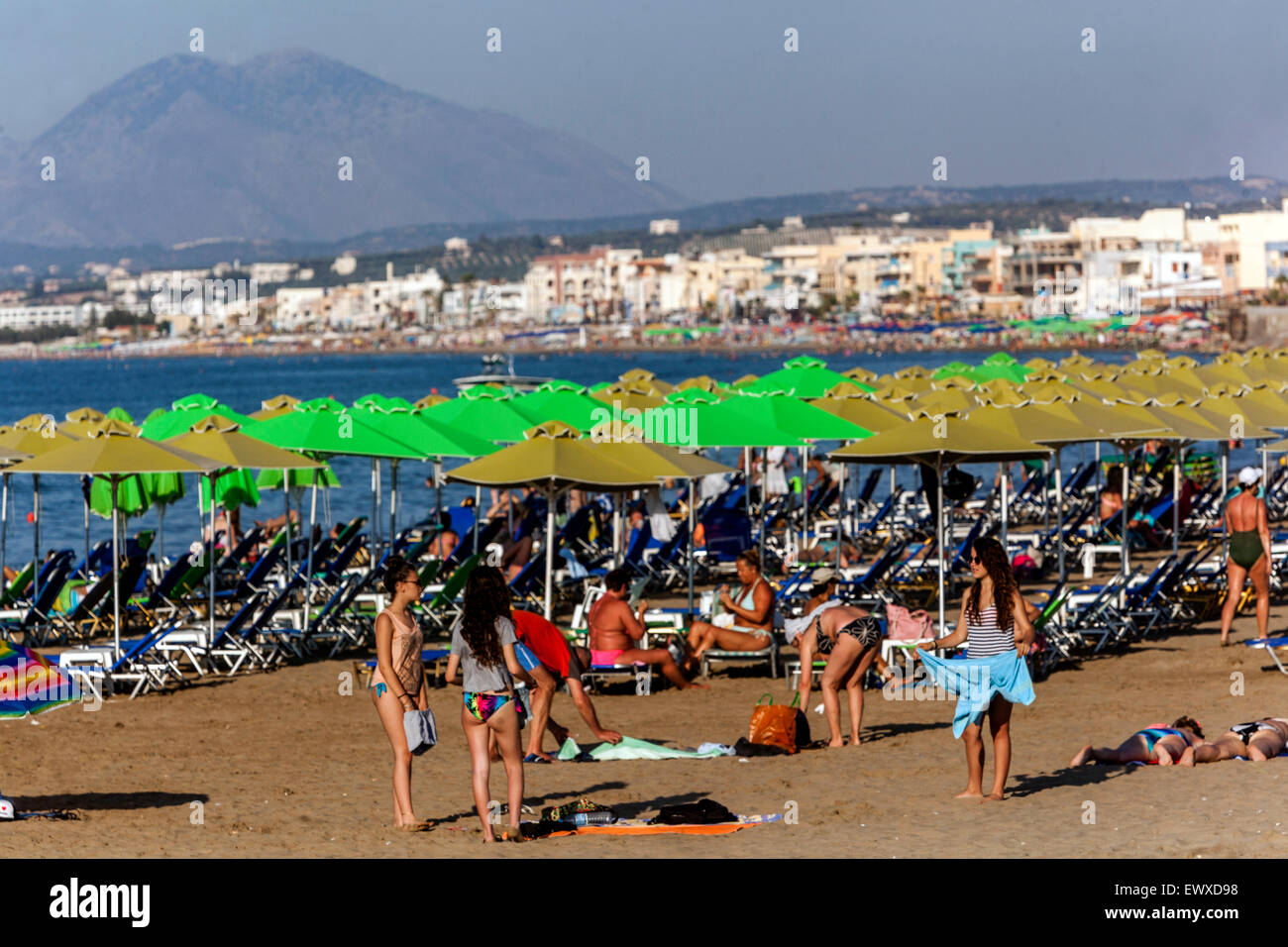 A crowd of people, Tourists relaxing on the sandy beach Rethymno Crete beach Greece beach sunbathers, holidaymakers Stock Photo