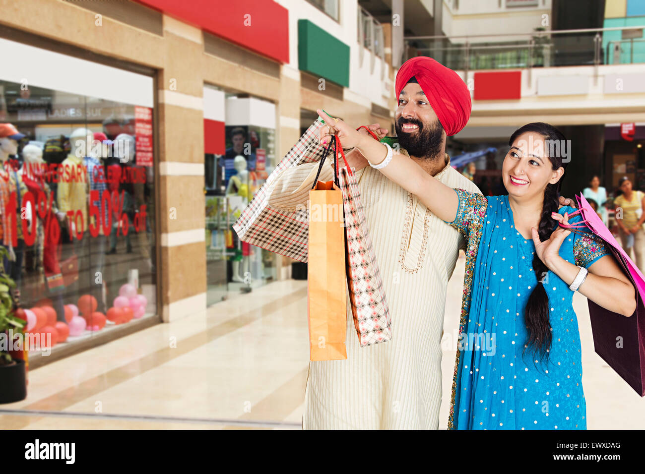 2 indian Punjabi Married Couple mall shopping finger pointing Stock ...