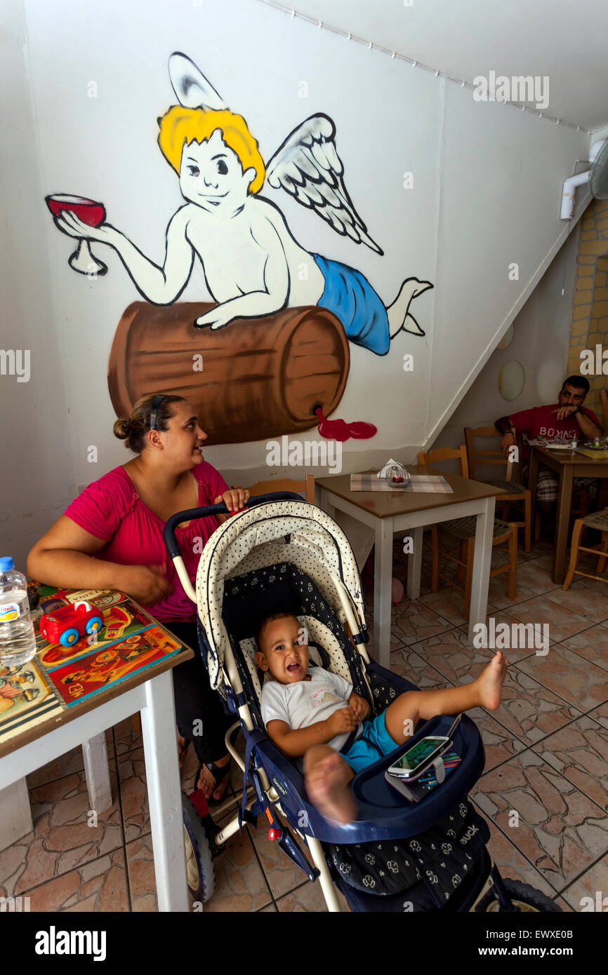 Street Bar, Tavern, Woman with her baby, toddler in pram Rethymno Crete Greece painting in cafe tavern interior painting Stock Photo