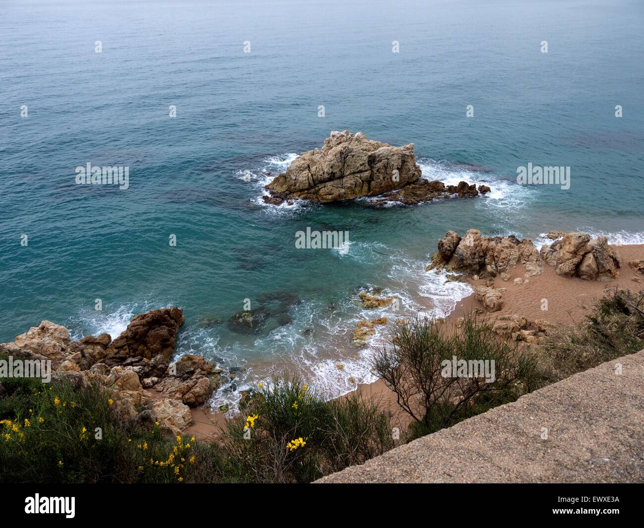 Rocks in a clear looking ocean on a beach Stock Photo - Alamy