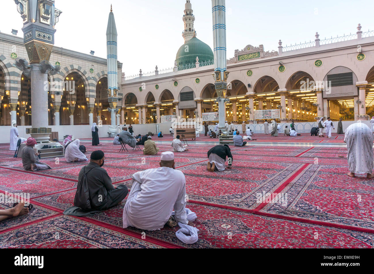 MEDINA, SAUDI ARABIA - MARCH 09, 2015 : Muslims read Quran and pray inside Nabawi mosque. Stock Photo