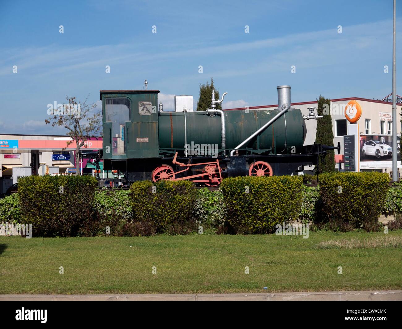 Train engine on a roundabout in Spain, indicating that the train station is here. Stock Photo