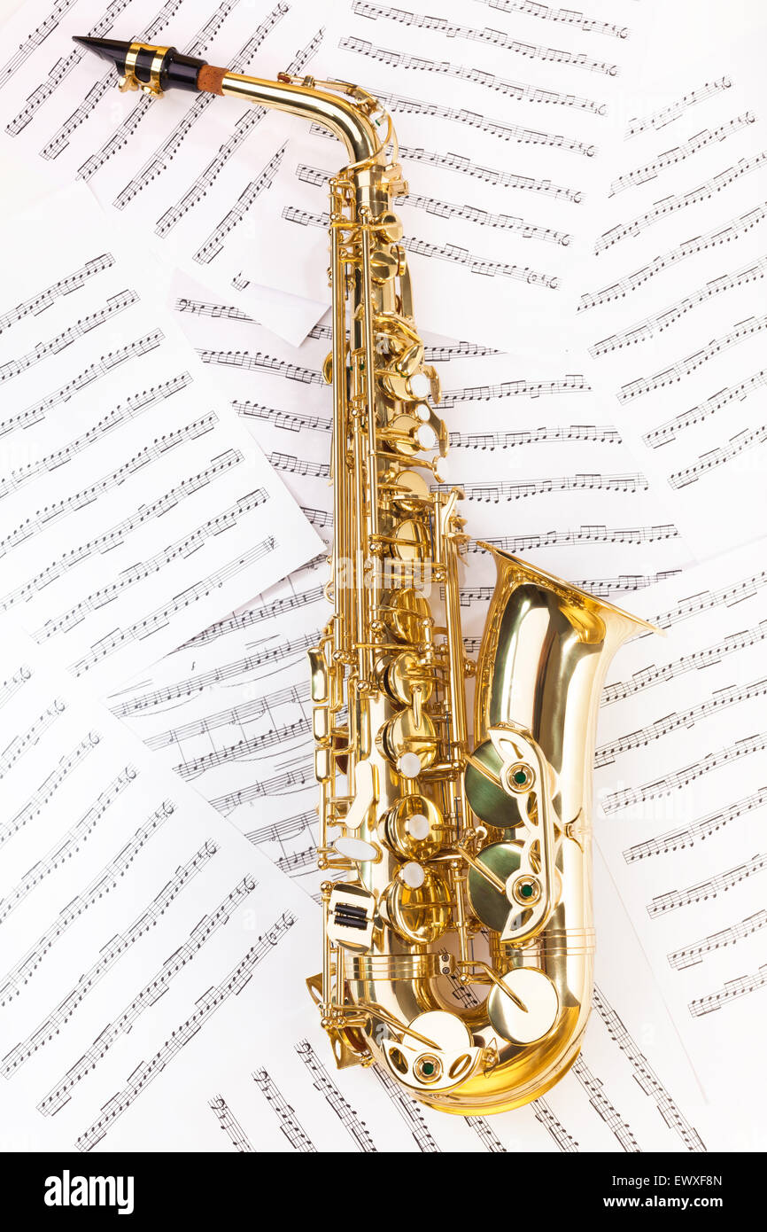 Shiny alto saxophone in full size on musical notes Stock Photo Alamy