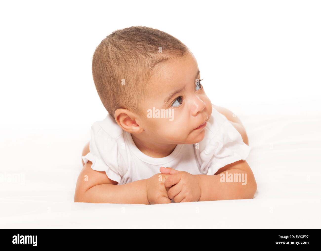 Curious looking African baby in white bodysuit Stock Photo