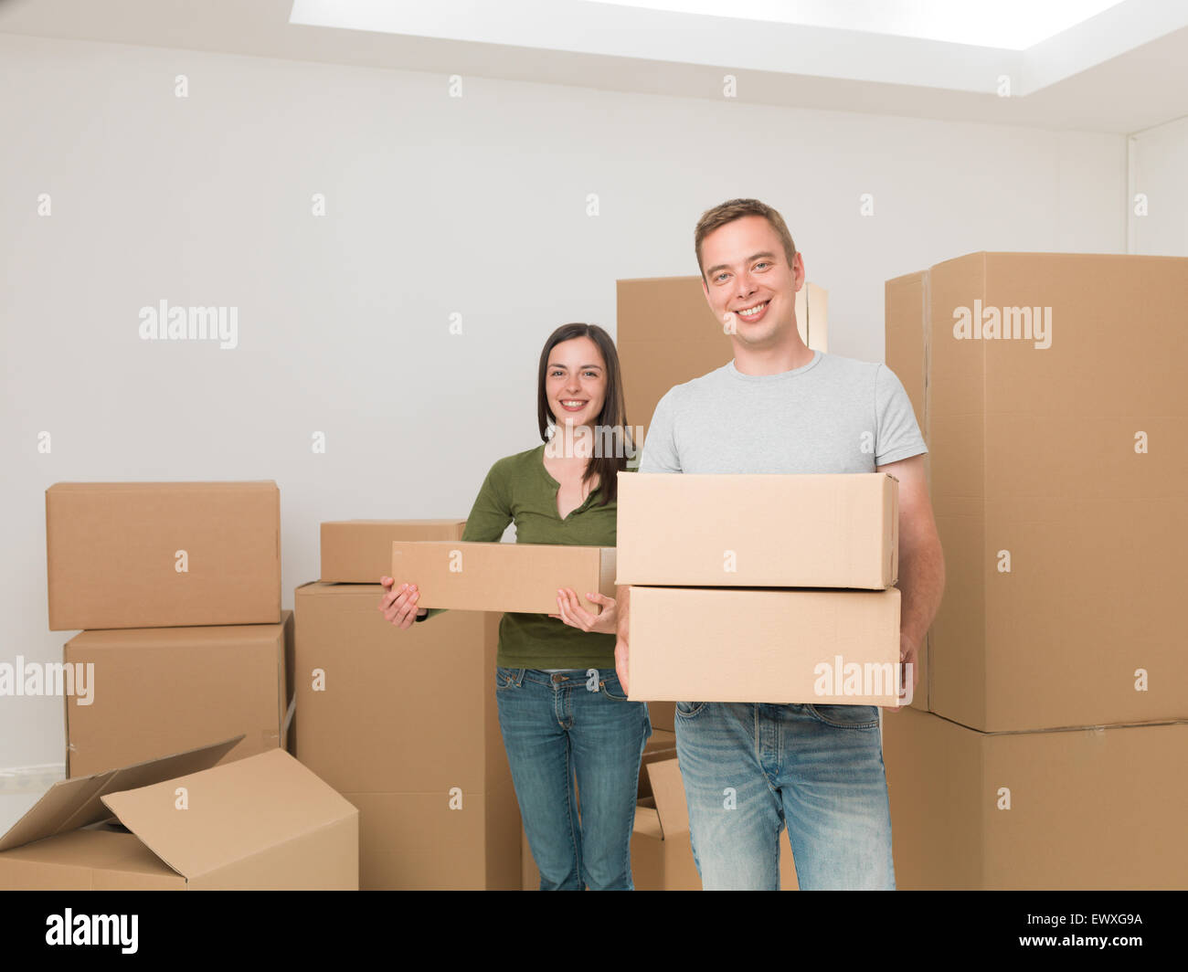 young happy couple carrying cardboard boxes, moving house Stock Photo ...