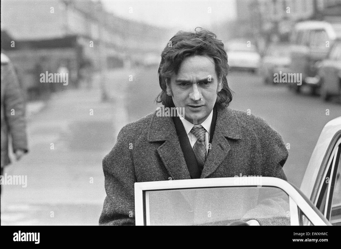 Dudley Moore gets into a car after removing his make-up during o filming a BBC comedy feature called 'An Apple A Day' in Liverpool Road, Reading. Traces of the make-up can still be seen around his nose Circa October 1970 Stock Photo