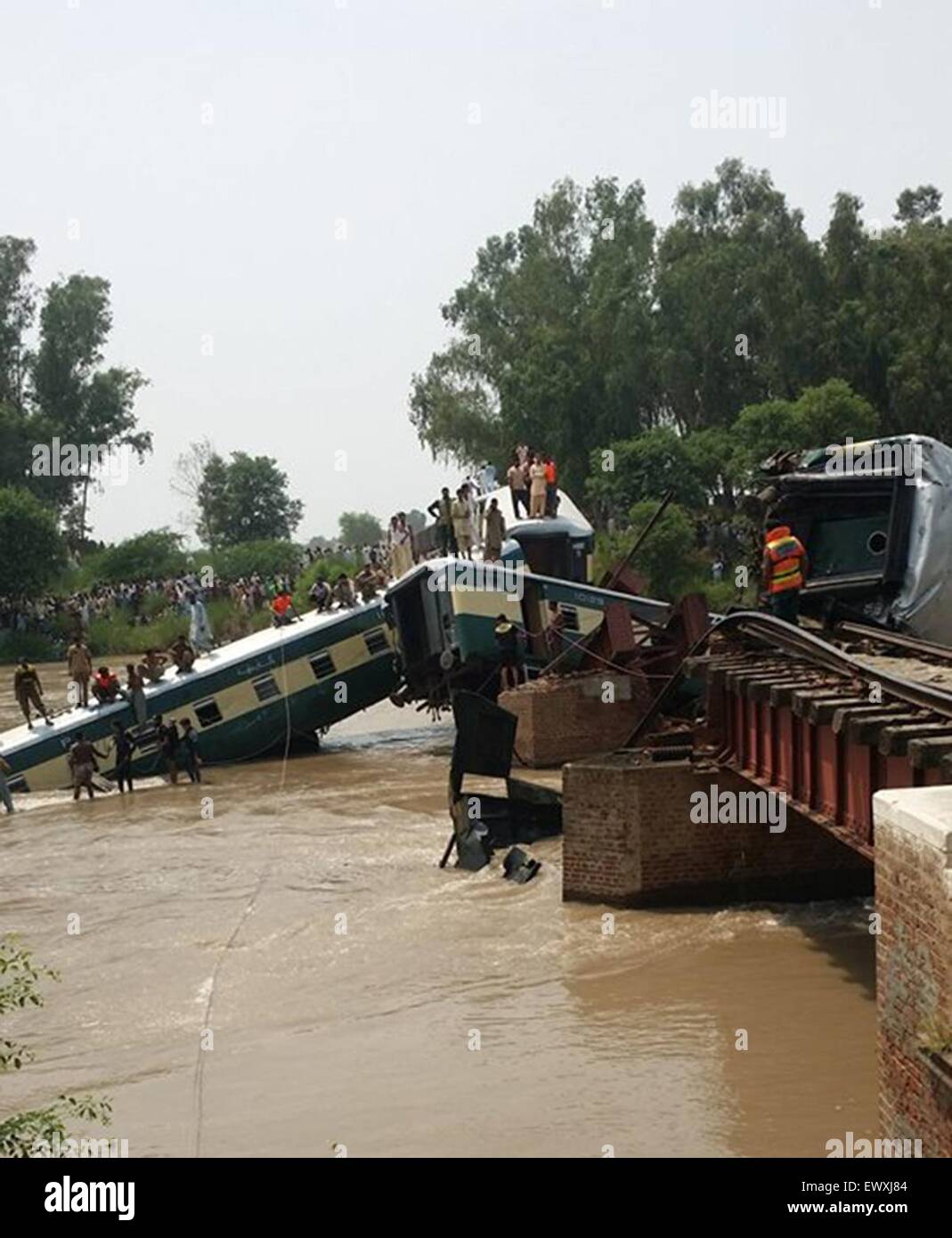 Gujranwala. 2nd July, 2015. Rescuers and local residents take part in a search operation after train compartments fell into a canal in east Pakistan's Gujranwala, July 2, 2015. At least 12 people were killed, over 100 others injured and at least four people went missing when four compartments of a train fell into a canal while crossing a bridge in Pakistan's city of Gujranwala on Thursday afternoon, local media and officials said. Credit:  Stringer/Xinhua/Alamy Live News Stock Photo
