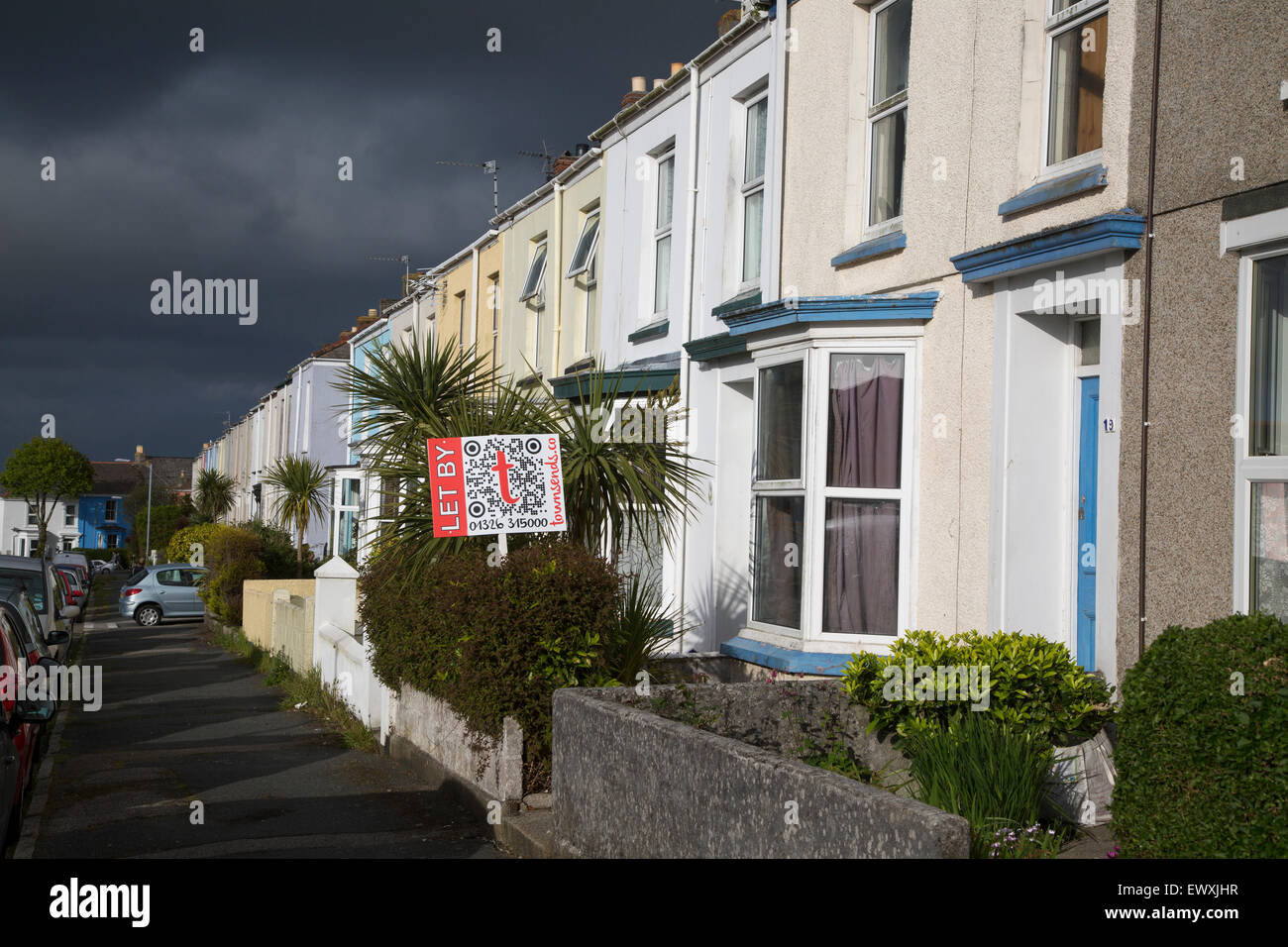 Terraced housing with letting signs  in Falmouth, Cornwall, England, UK with storm clouds overhead Stock Photo