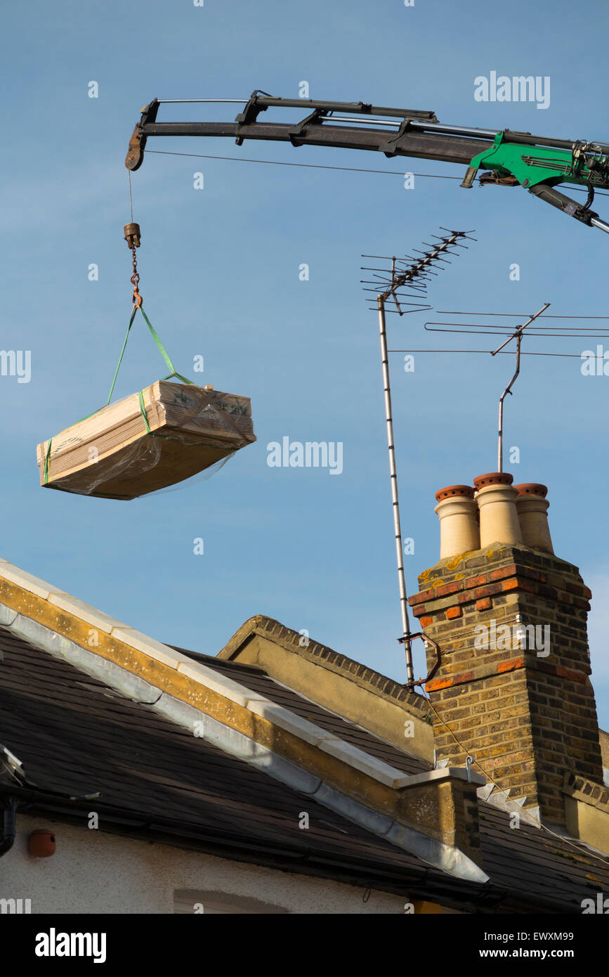 Timber / wood / planks / joist / joists being delivered by crane to a