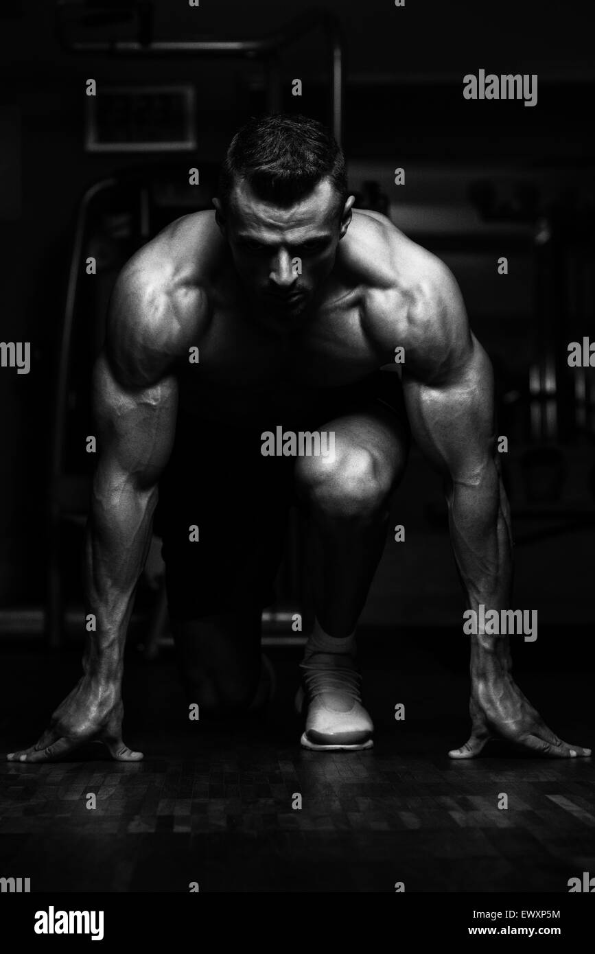 Strong Muscular Men Kneeling On The Floor Almost Like Sprinter