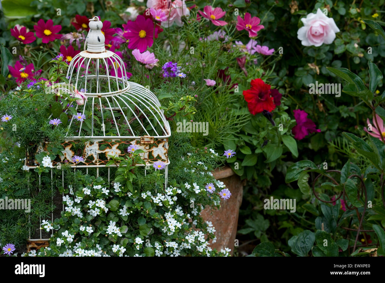 country cottage garden flower borders and birdcage planter Stock Photo