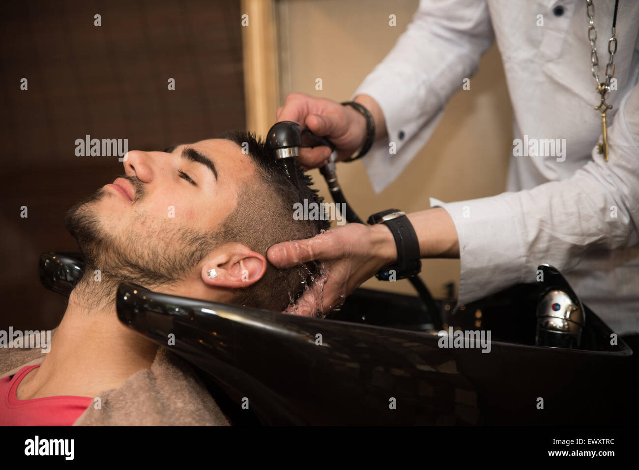 Hairstylist Hairdresser Washing Customer Hair - Young Man Relaxing In Hairdressing Beauty Salon Stock Photo
