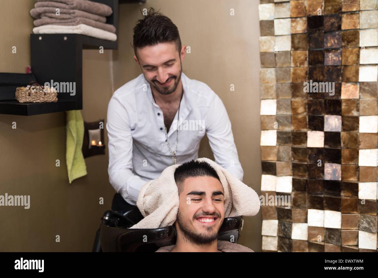 Hairstylist Hairdresser Washing Customer Hair - Young Man Relaxing In Hairdressing Beauty Salon Stock Photo