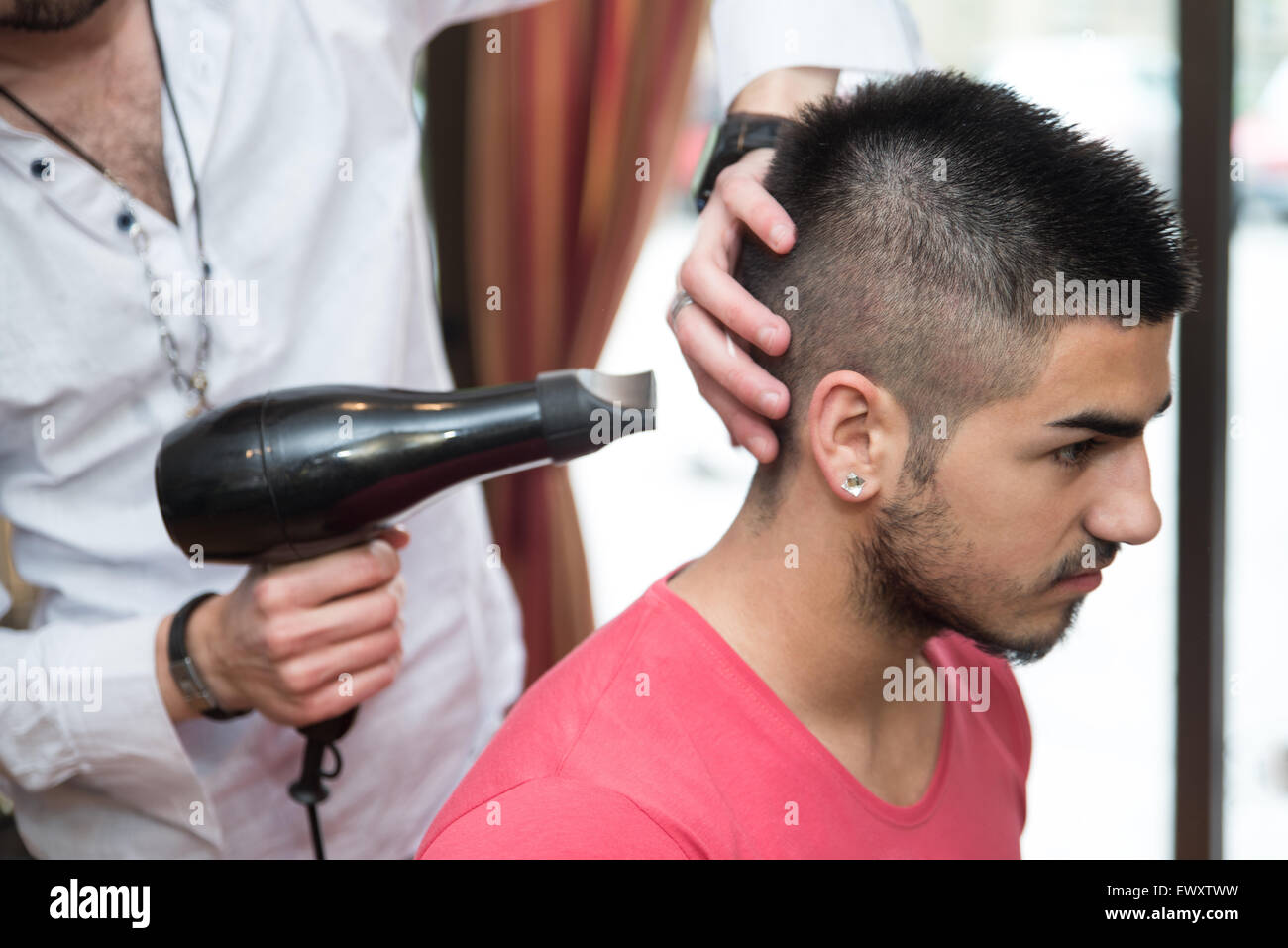 Handsome Man At The Hairdresser Blow Drying His Hair Stock Photo