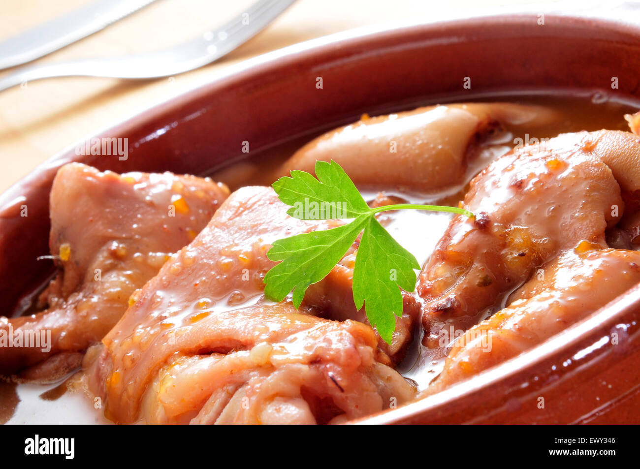 closeup of a earthenware casserole with manitas de cerdo, stewed pig feet typical of Spain Stock Photo