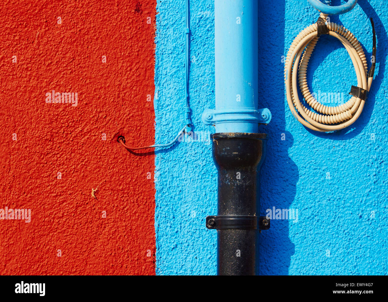 Pipes and wires on blue and rust coloured wall Burano Venetian Lagoon Veneto Italy Europe Stock Photo