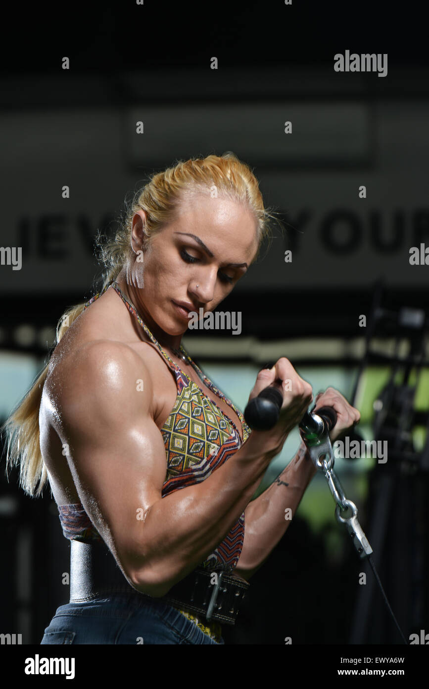 Female bodybuilder with messy short brown bun hair. Big biceps - Playground