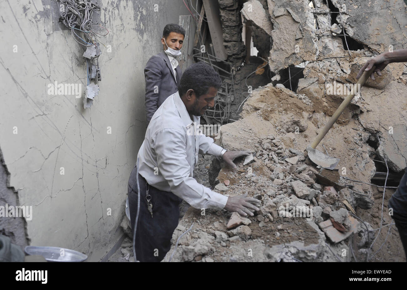 Sanaa, Yemen. 2nd July, 2015. Two Yemenis stand in a house destroyed in the airstrike in Sanaa, Yemen, on July 2, 2015. Airstrikes of the Saudi-led coalition forces hit the house of former Yemeni Prime Minister Faraj Said Bin Ghanem in Sanaa on Thursday, killing the family of a guard including three children and the parents. Faraj Said Bin Ghanem was the prime minister of Yemen from May 1997 to April 1998. Credit:  Hani Ali/Xinhua/Alamy Live News Stock Photo