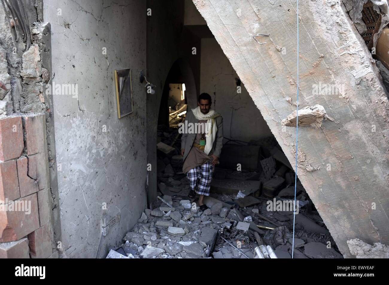 Sanaa, Yemen. 2nd July, 2015. A Yemeni man walks in a house destroyed in the airstrike in Sanaa, Yemen, on July 2, 2015. Airstrikes of the Saudi-led coalition forces hit the house of former Yemeni Prime Minister Faraj Said Bin Ghanem in Sanaa on Thursday, killing the family of a guard including three children and the parents. Faraj Said Bin Ghanem was the prime minister of Yemen from May 1997 to April 1998. Credit:  Hani Ali/Xinhua/Alamy Live News Stock Photo