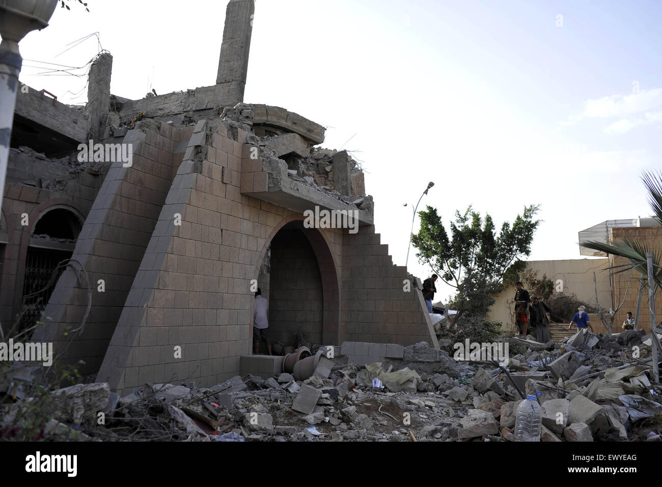 Sanaa, Yemen. 2nd July, 2015. Yemenis gather outside a house destroyed in the airstrike in Sanaa, Yemen, on July 2, 2015. Airstrikes of the Saudi-led coalition forces hit the house of former Yemeni Prime Minister Faraj Said Bin Ghanem in Sanaa on Thursday, killing the family of a guard including three children and the parents. Faraj Said Bin Ghanem was the prime minister of Yemen from May 1997 to April 1998. Credit:  Hani Ali/Xinhua/Alamy Live News Stock Photo
