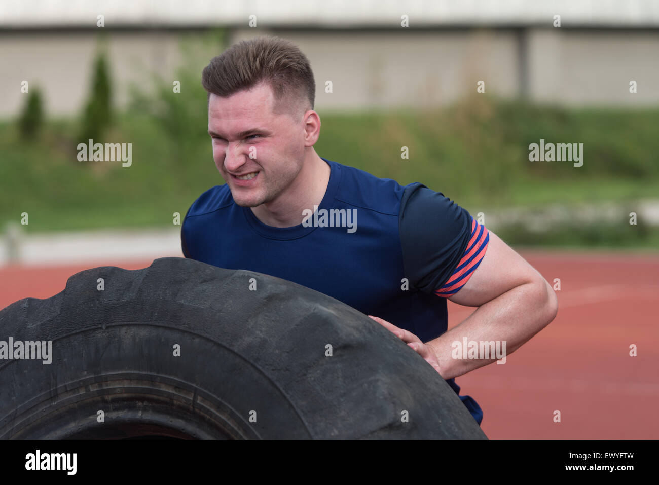 Young Man Turning Tire Over Bodybuilding Exercises Truck Tire Stock