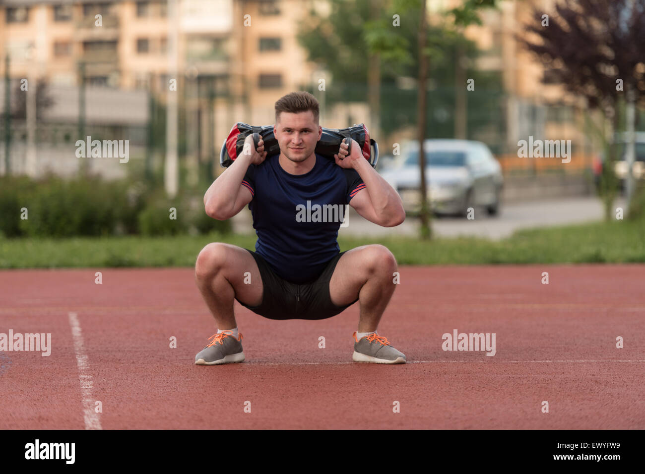 Young Man Performing Bag Squat Exercise Outdoor Stock Photo Alamy