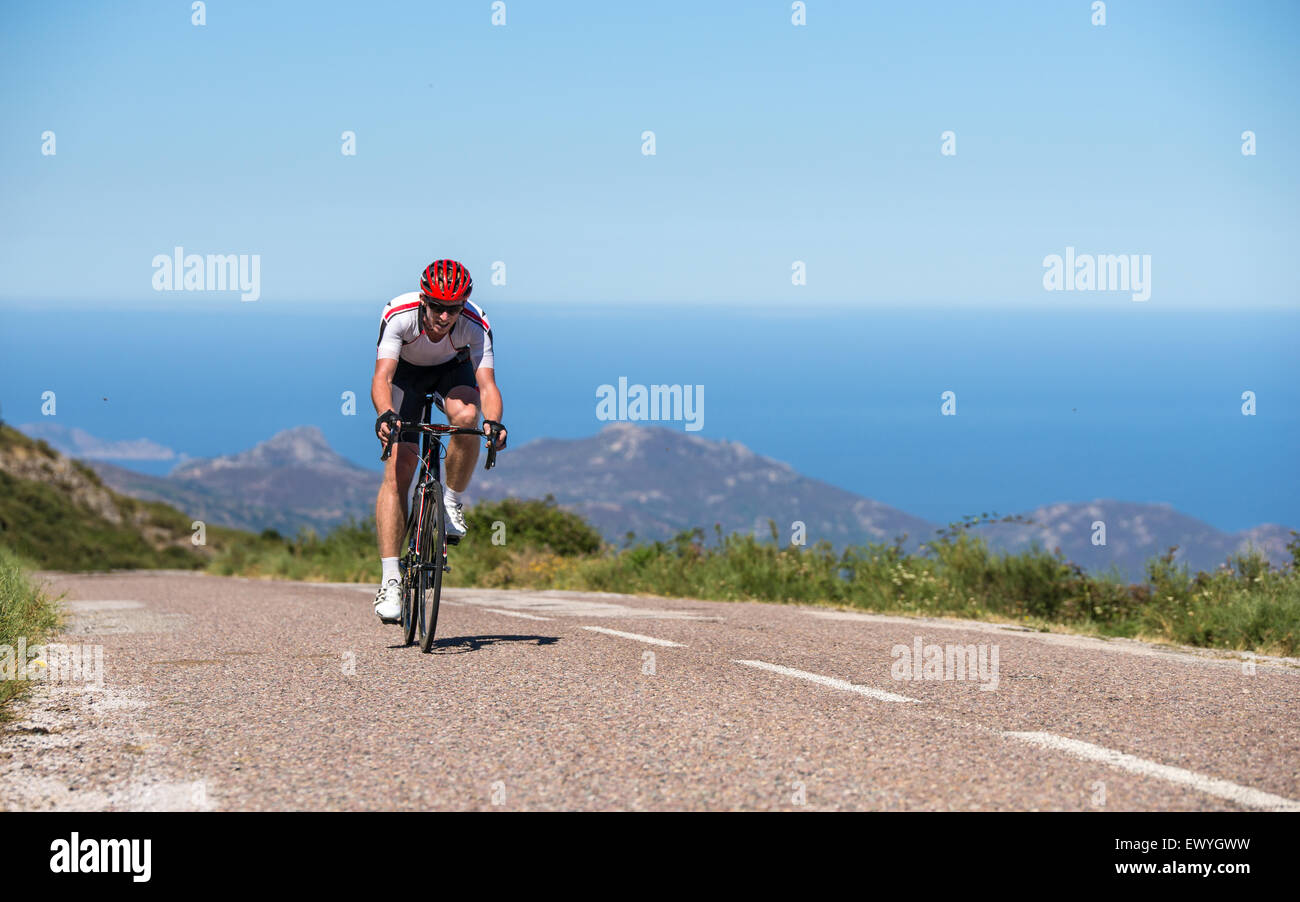 Man cycling on road, Corsica, France Stock Photo