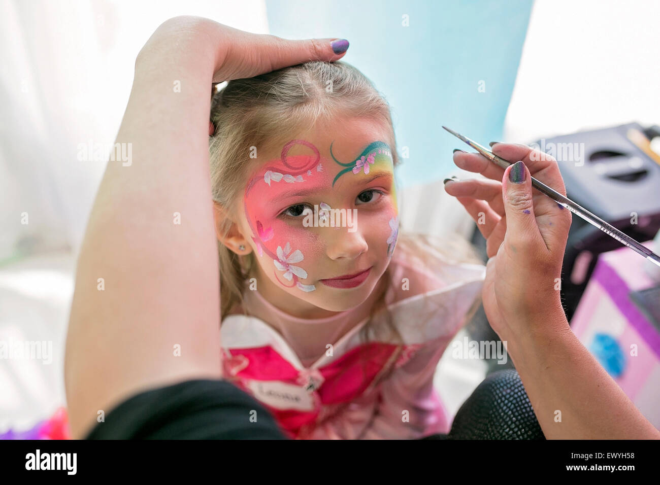 Little girl having her face painted Stock Photo