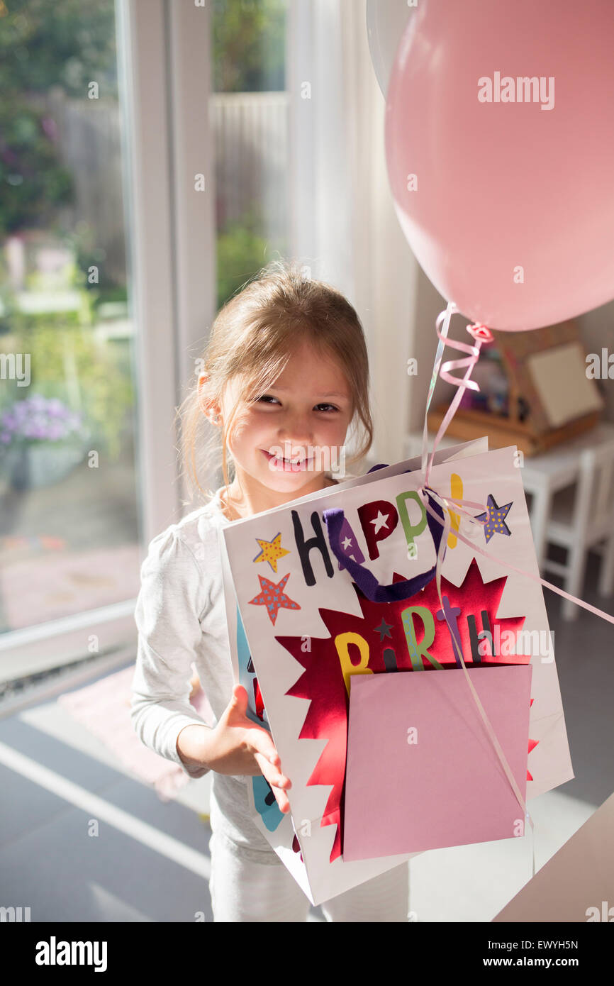 Girl holding birthday present and a balloon Stock Photo