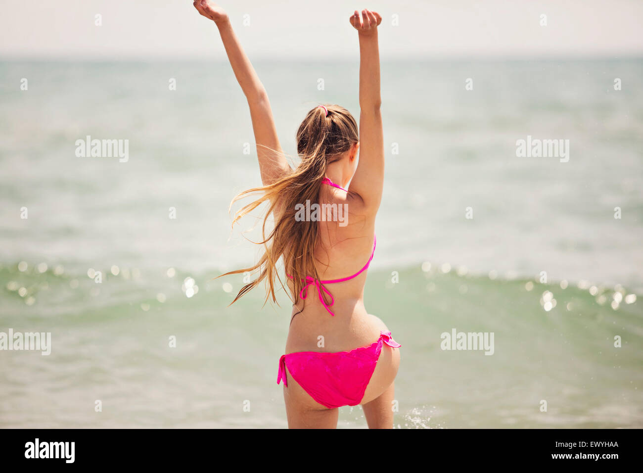 Teenage girl jumping up in the air on the beach Stock Photo