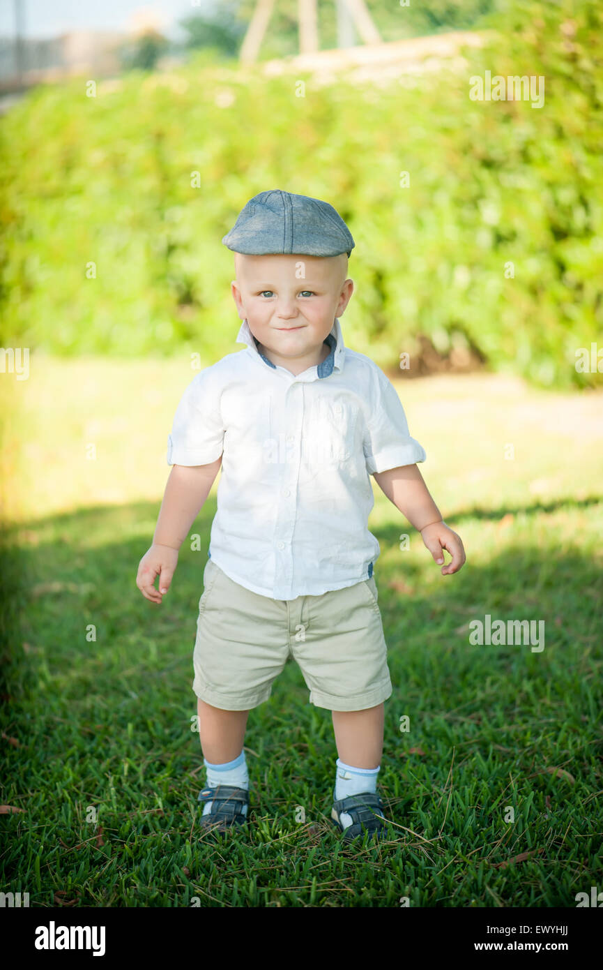 Cute little boy in a cap on a background of nature Stock Photo