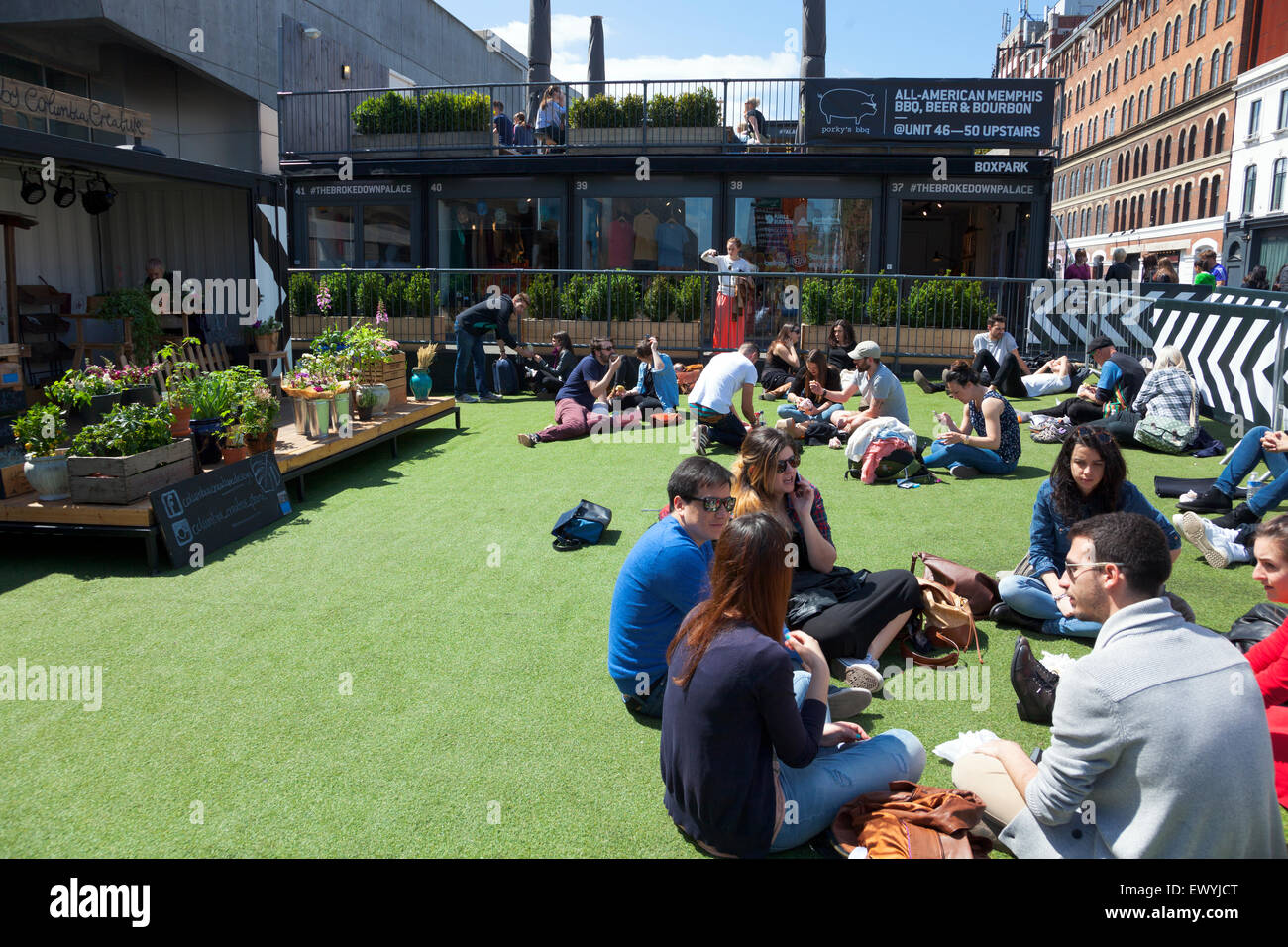 People sitting and relaxing in the summer at the Boxpark in Shoreditch, London, England Stock Photo