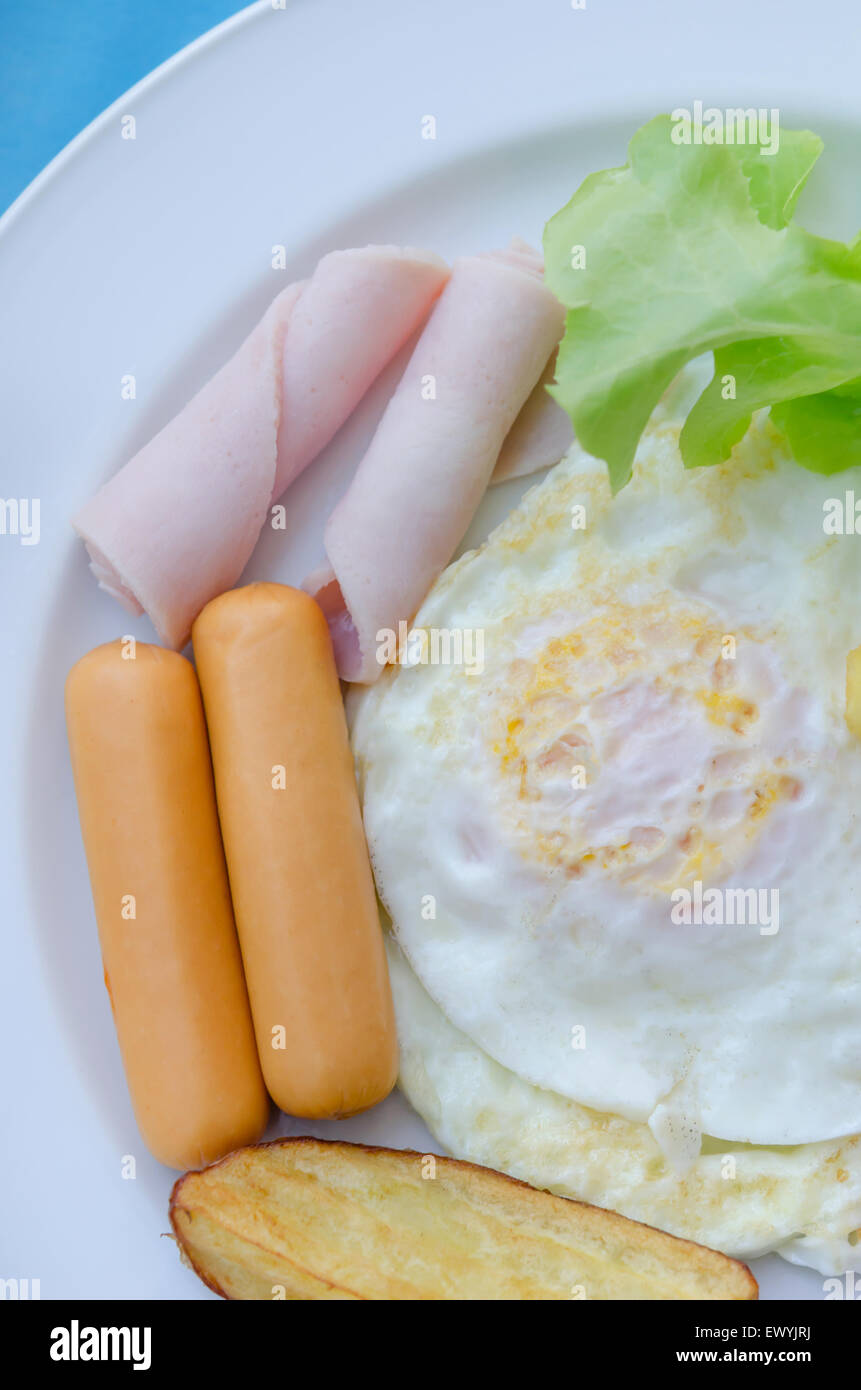 fried egg , ham , sausage and grilled potato on dish , fresh breakfast