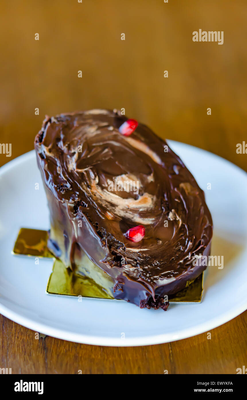 Chocolate yule log cake with red pomegranate Stock Photo