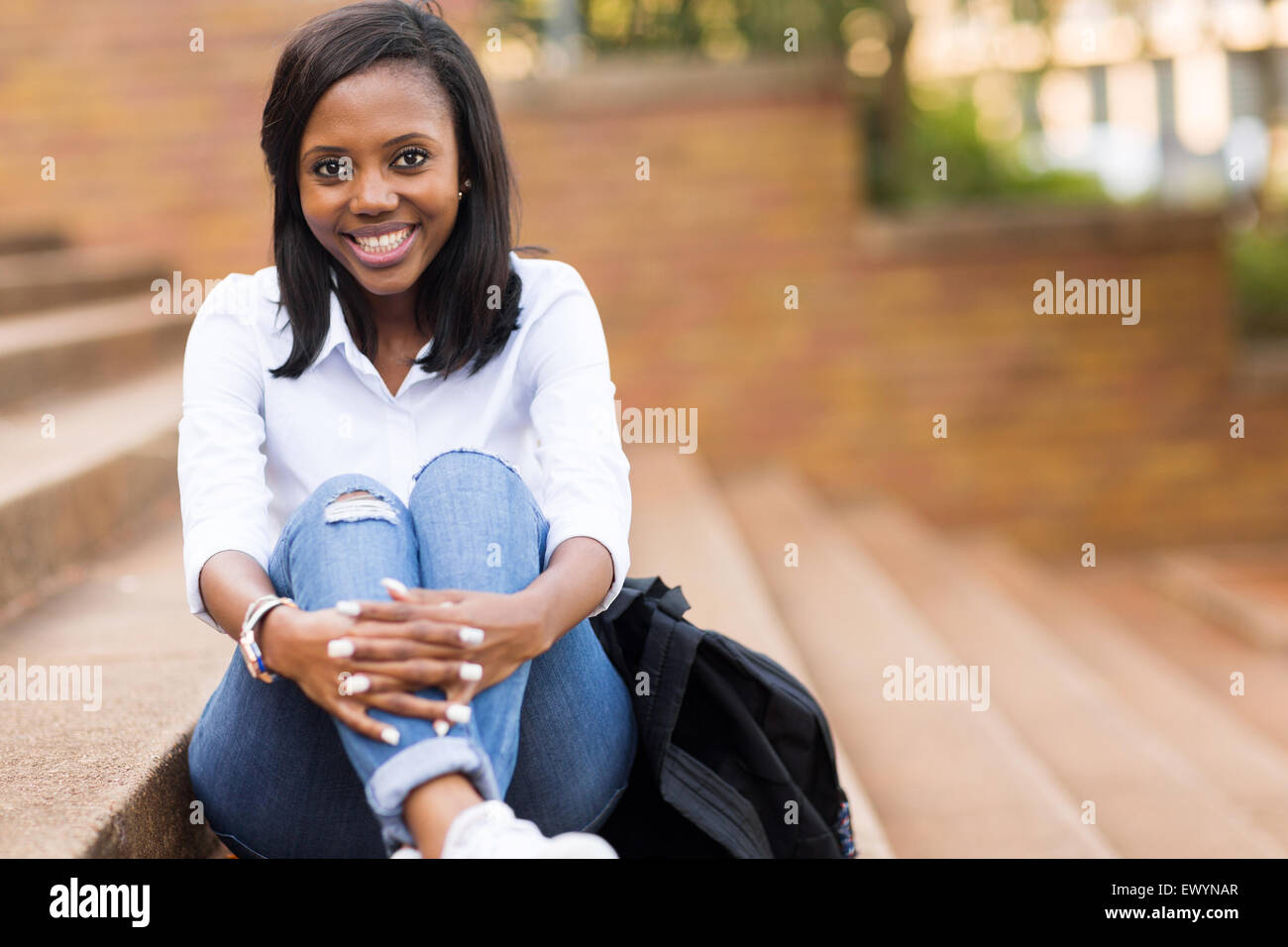 gorgeous young female African college student sitting outdoors Stock ...