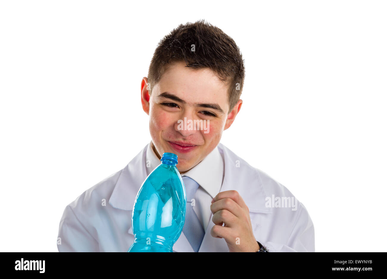A boy doctor in blue tie and white coat  drinking water from plastic bottle. His acne skin has not ben retouched Stock Photo