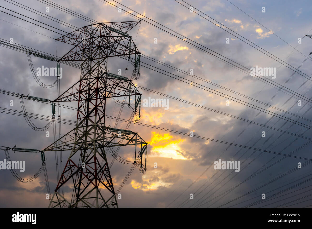 Electricity pylons and cable lines during sunset Stock Photo - Alamy