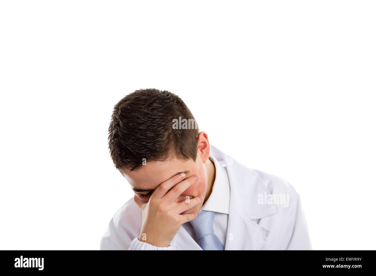 A boy doctor in white coat and blue tie helps to feel medicine more friendly: he is smiling while covering his face. His acne skin has not ben retouched Stock Photo