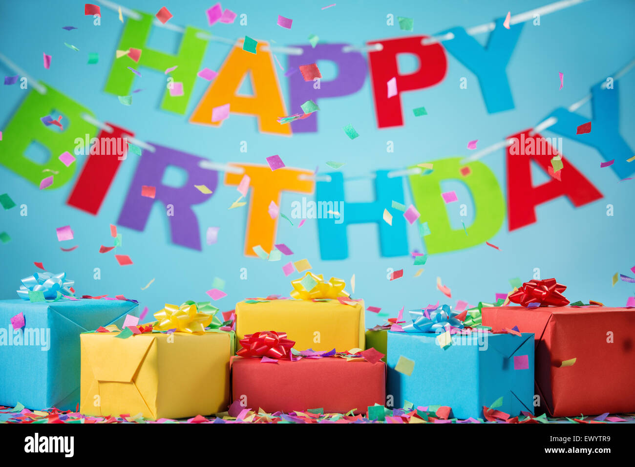 Birthday gift boxes with paper confetti on blue background Stock Photo