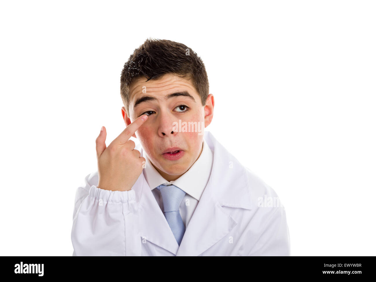 A boy doctor in white coat and blue tie helps to feel medicine more friendly: he is touching his eye with finger. His acne skin has not ben retouched Stock Photo