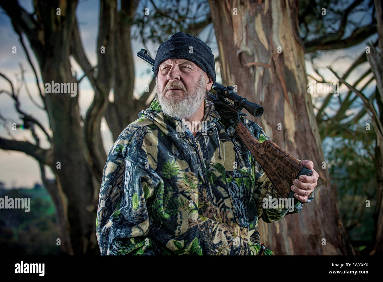 Experienced hunter resting a rifle on his shoulder Stock Photo