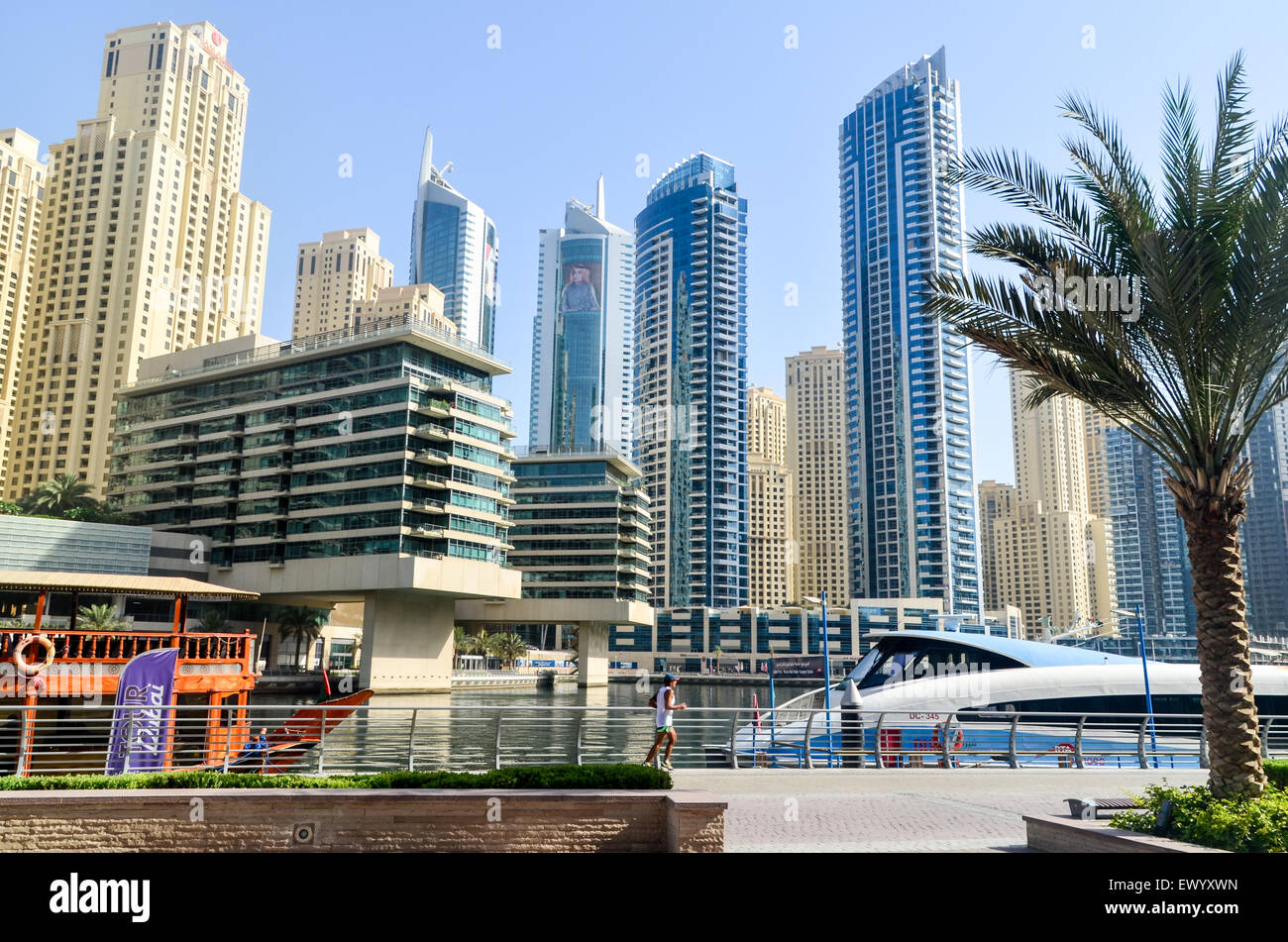 Runner jogging on the promenade near the futuristic skyline of the Dubai Marina, United Arab Emirates Stock Photo
