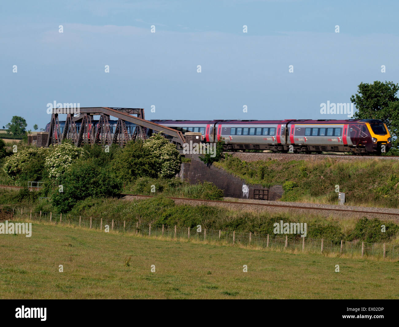 Arriva UK Trains, Cross Country train coming over a truss railway bridge on the Somerset Levels, UK Stock Photo