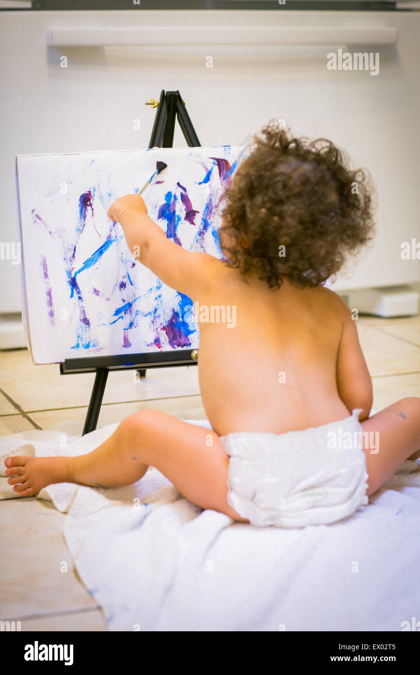 Little girl painting in kitchen Stock Photo